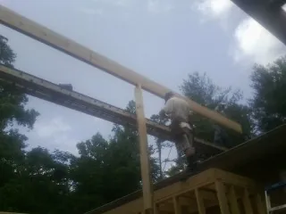 Carpenter setting a ridge beam over a new addition frame — Ice Dam Removal by Roofing Brothers in Cheyney