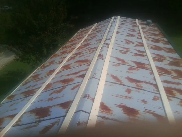 Rusted metal roof panels with new wood purlins before replacement — Storm Damage Roof Repair in Cheyney by Roofing Brothers