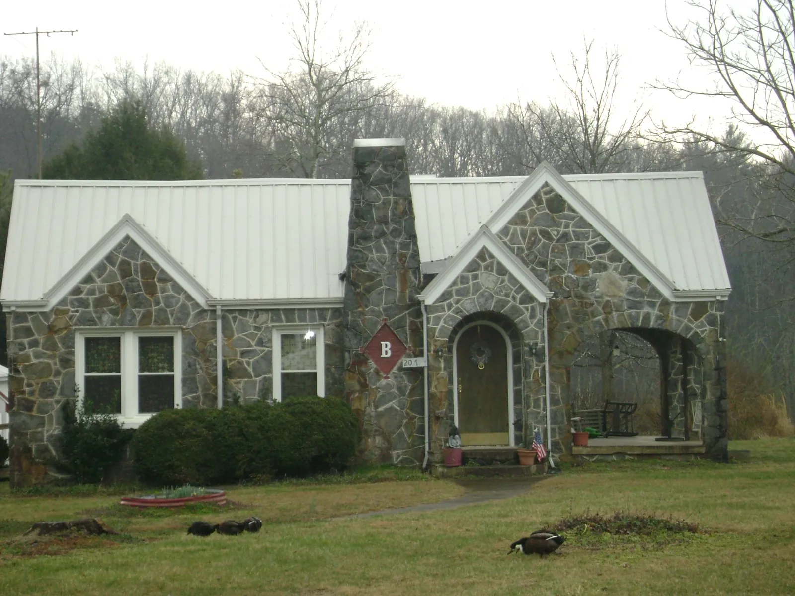 White metal roof on a stone cottage with steep gables in Cheyney