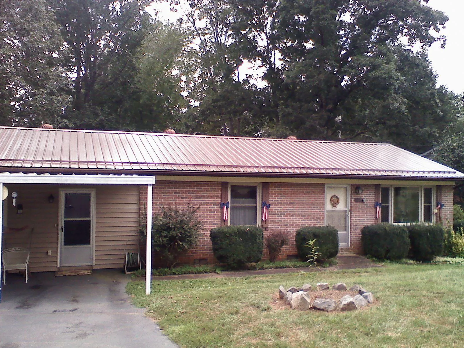 Bronze metal roof and carport on a brick ranch home — Roof Repair work by our crew in Cheyney